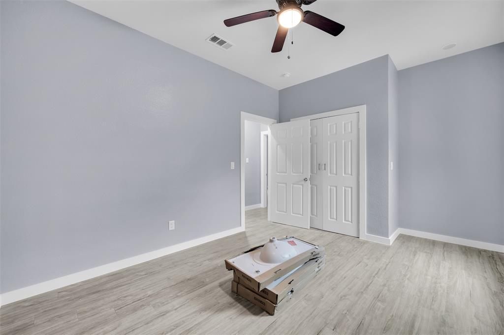409 Dallas Street Rice, TX 75155 - Photo 19 of 26 an empty room with wooden floor and ceiling fan