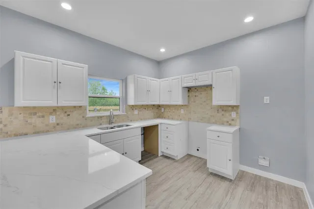 a kitchen with a sink cabinets and wooden floor