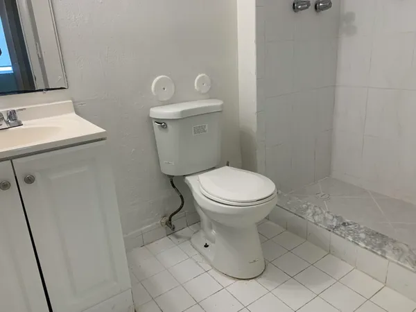 a white toilet sitting next to a bathroom sink