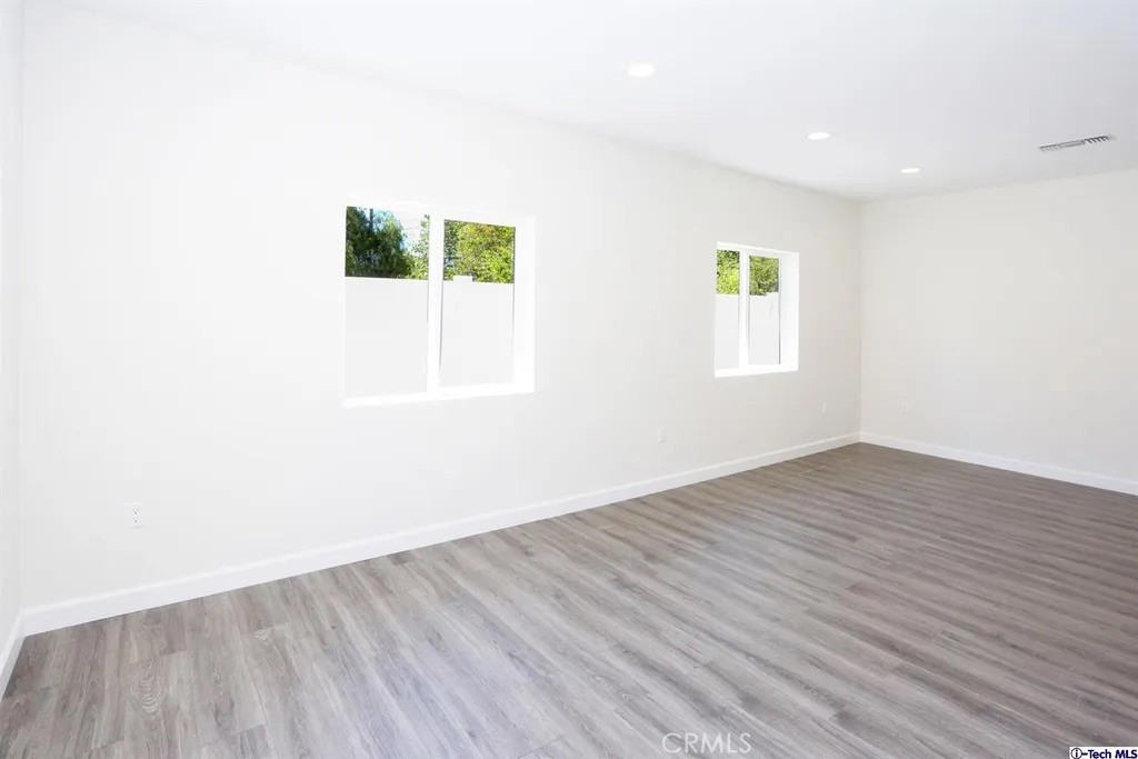 7521 Milwood Avenue Canoga Park, CA 91303 - Photo 2 of 15 an empty room with wooden floor and windows