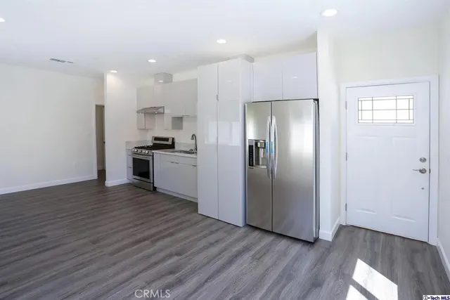 a kitchen with stainless steel appliances granite countertop a refrigerator and a stove top oven