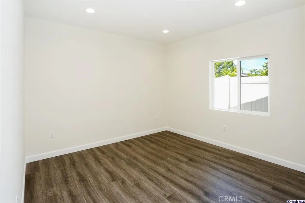 7521 Milwood Avenue Canoga Park, CA 91303 - Photo 10 of 15 a view of an empty room with wooden floor and a window