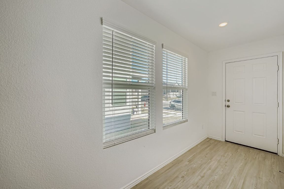 210 Sormonne Loop Kyle, TX 78640 - Photo 3 of 17 a view of an empty room with wooden floor and a window