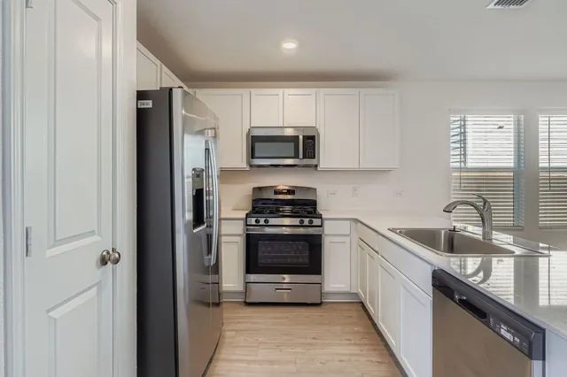a kitchen with stainless steel appliances granite countertop a stove a sink and a refrigerator