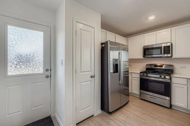 a kitchen with stainless steel appliances a refrigerator stove and microwave