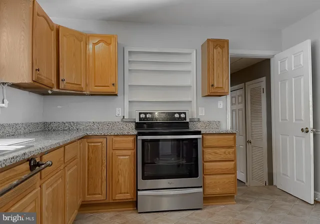 a kitchen with stainless steel appliances kitchen island granite countertop a stove sink and cabinets