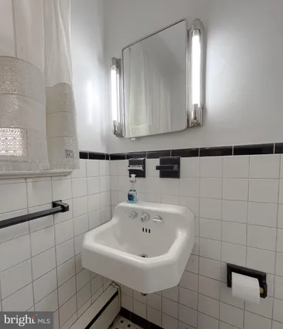 a bathroom with a sink a toilet a mirror and shower