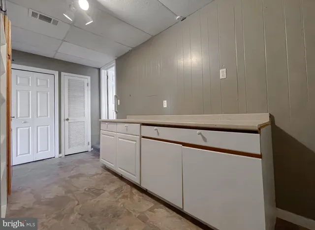 a kitchen with a table chairs sink and cabinets