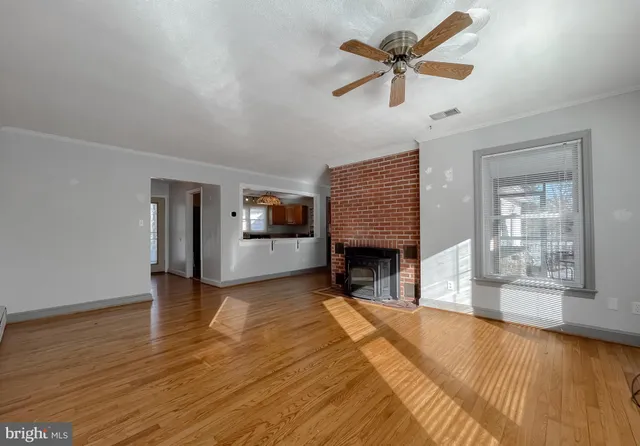 a view of empty room with fireplace and wooden floor