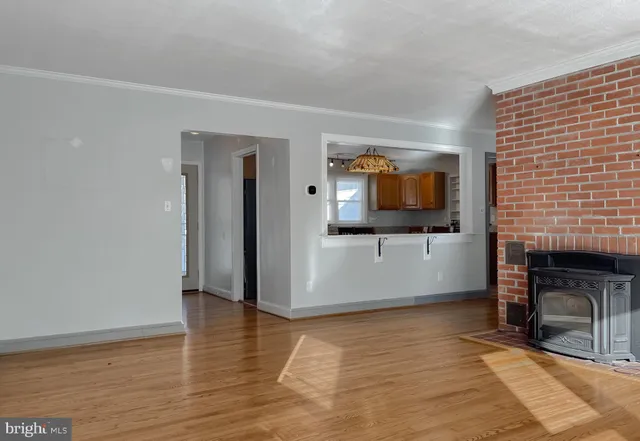 a view of a livingroom with wooden floor and a fireplace