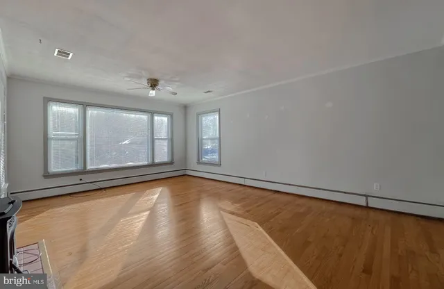 a view of a room with wooden floor and natural light