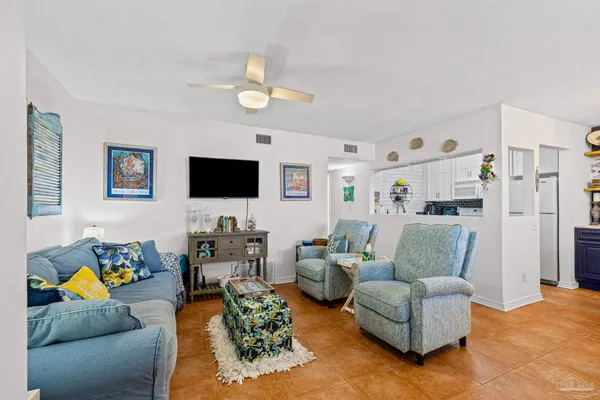 a living room with furniture kitchen view and a flat screen tv