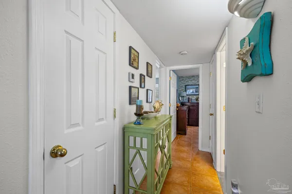a view of a hallway to a livingroom with furniture and staircase