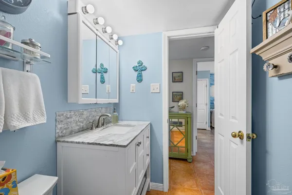 a en suite bathroom with a granite countertop sink and a mirror