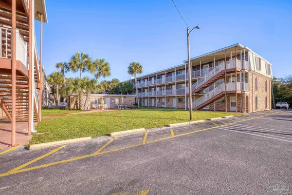 a view of a big building with a big yard and large trees