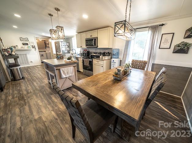 8331 Hills-View Road Oakboro, NC 28129 - Photo 17 of 34 a kitchen with stainless steel appliances granite countertop a stove a refrigerator a oven a sink a dining table and chairs with wooden floor
