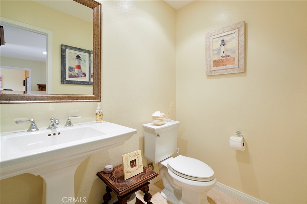 4 Lucerne, Unit 22 Newport Beach, CA 92660 - Photo 15 of 23 a bathroom with a toilet a sink and mirror