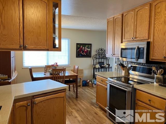 1201 Beldon Way Reno, NV 89503 - Photo 8 of 22 a kitchen with stainless steel appliances a stove a sink a microwave and wooden cabinets