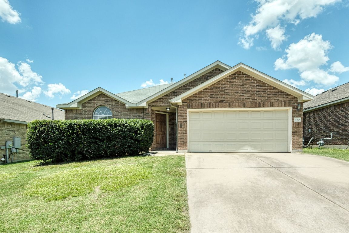 a front view of a house with yard and garage