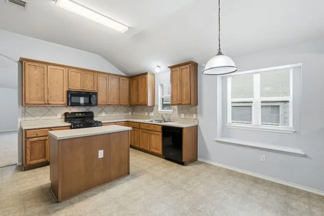 a kitchen with stainless steel appliances granite countertop a stove sink microwave and refrigerator