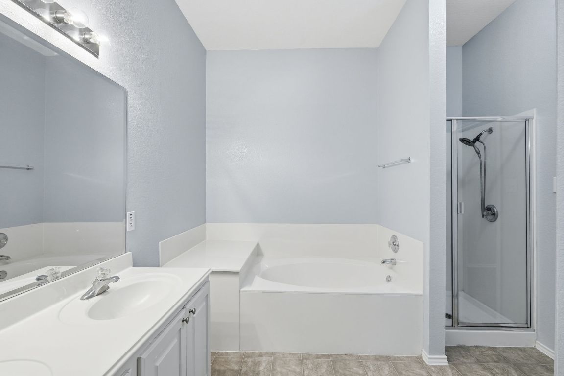 1910 Rachel Lane Round Rock, TX 78664 - Photo 10 of 17 a bathroom with a tub sink and mirror