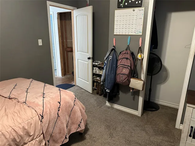 a bedroom with a bed and dresser with mirror