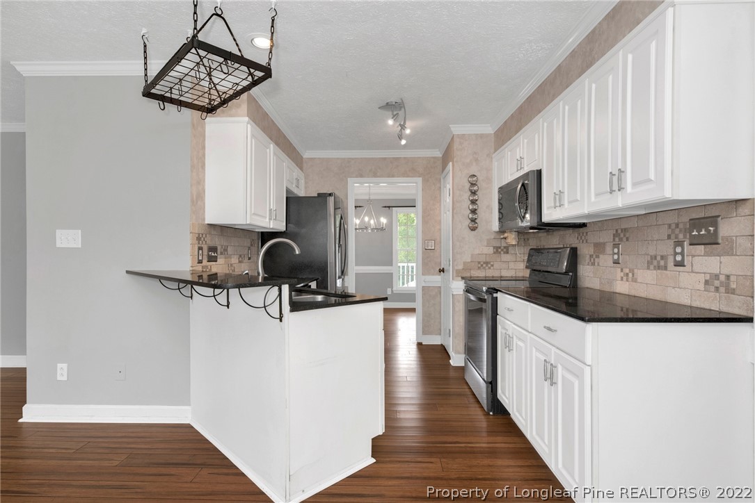 338 Lionshead Road Fayetteville, NC 28311 - Photo 14 of 39 a kitchen with stainless steel appliances granite countertop a sink dishwasher a stove and a refrigerator with wooden floor
