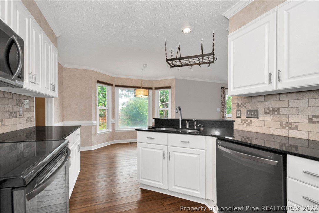 338 Lionshead Road Fayetteville, NC 28311 - Photo 17 of 39 a kitchen with granite countertop a sink a stove and cabinets