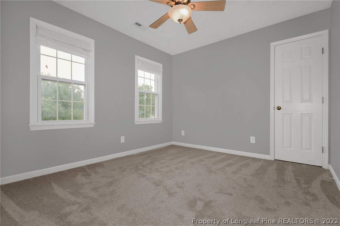 338 Lionshead Road Fayetteville, NC 28311 - Photo 26 of 39 an empty room with windows and chandelier fan