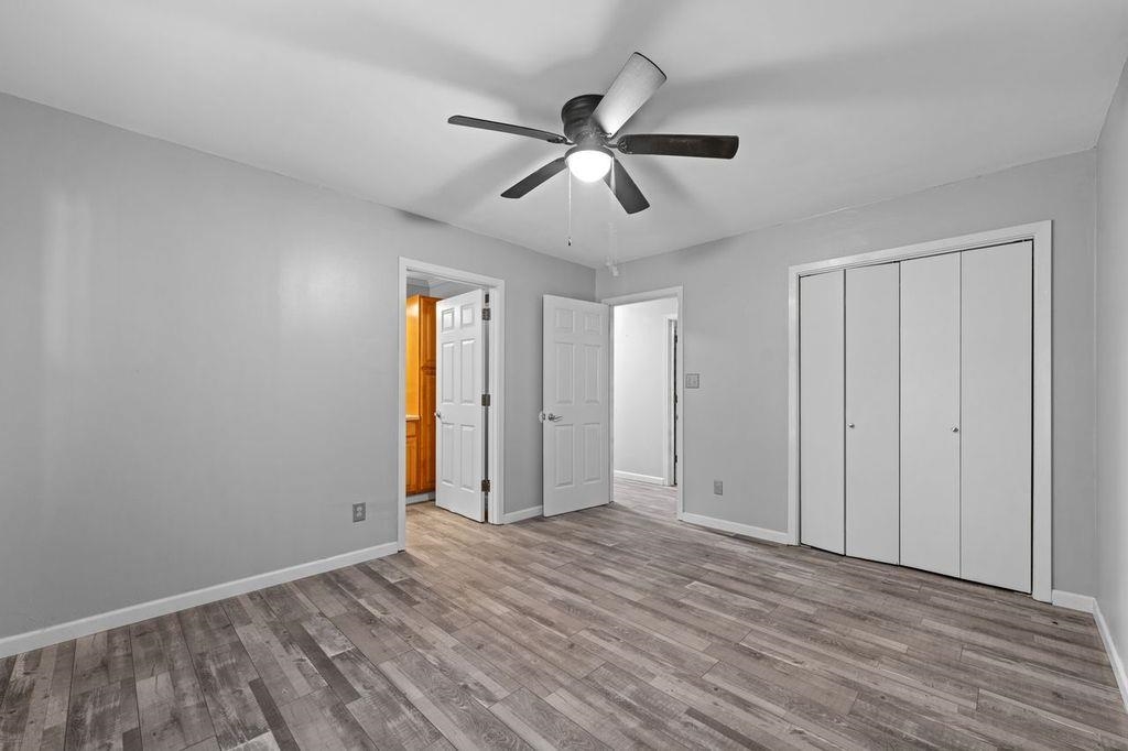 235 Hardeman Street Grand Junction, TN 38039 - Photo 16 of 20 an empty room with wooden floor ceiling fan and windows