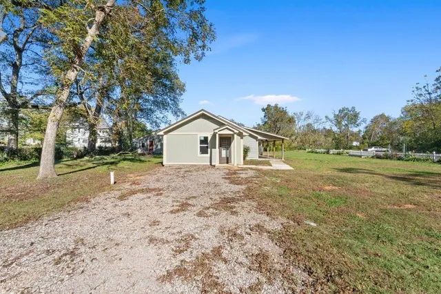 a view of backyard of house with trees