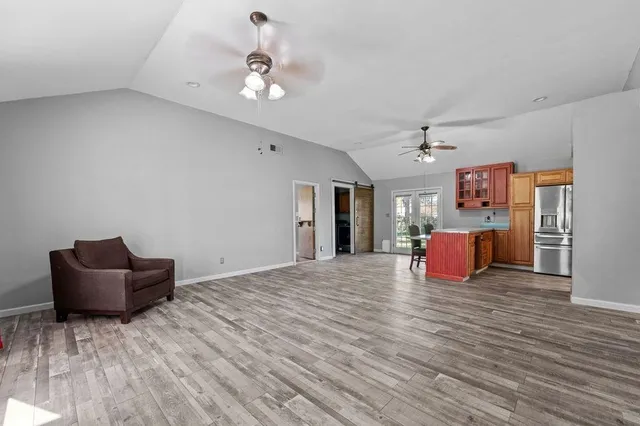 a large room with chandelier fan and wooden floor