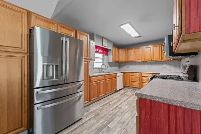 a kitchen with stainless steel appliances granite countertop a refrigerator stove and sink