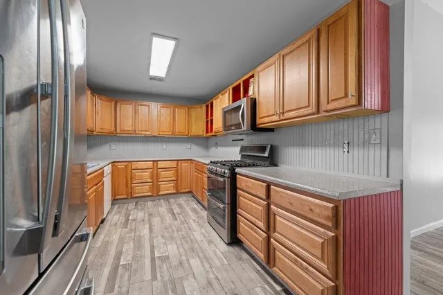 a kitchen with granite countertop wooden cabinets a sink and dishwasher