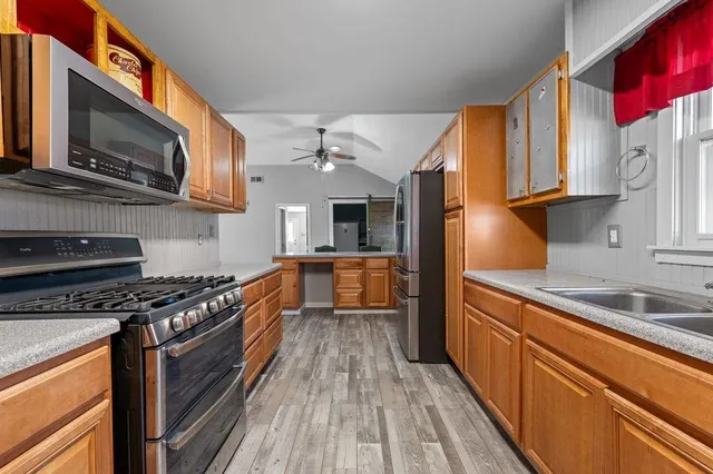 a kitchen with stainless steel appliances granite countertop a stove a sink and a microwave