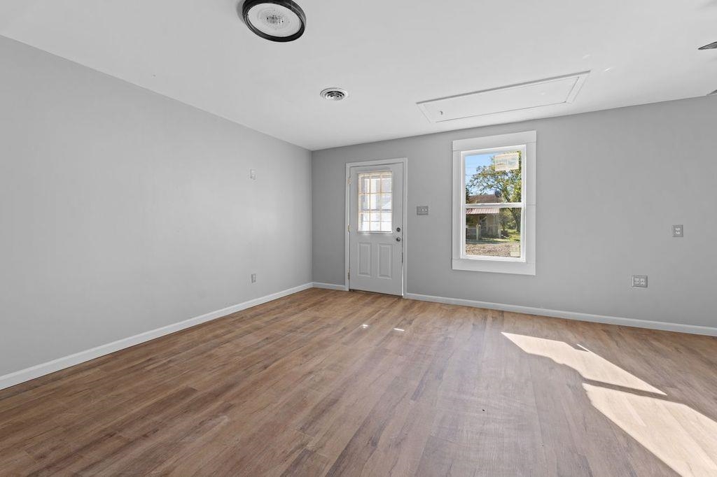 235 Hardeman Street Grand Junction, TN 38039 - Photo 10 of 20 an empty room with wooden floor and windows
