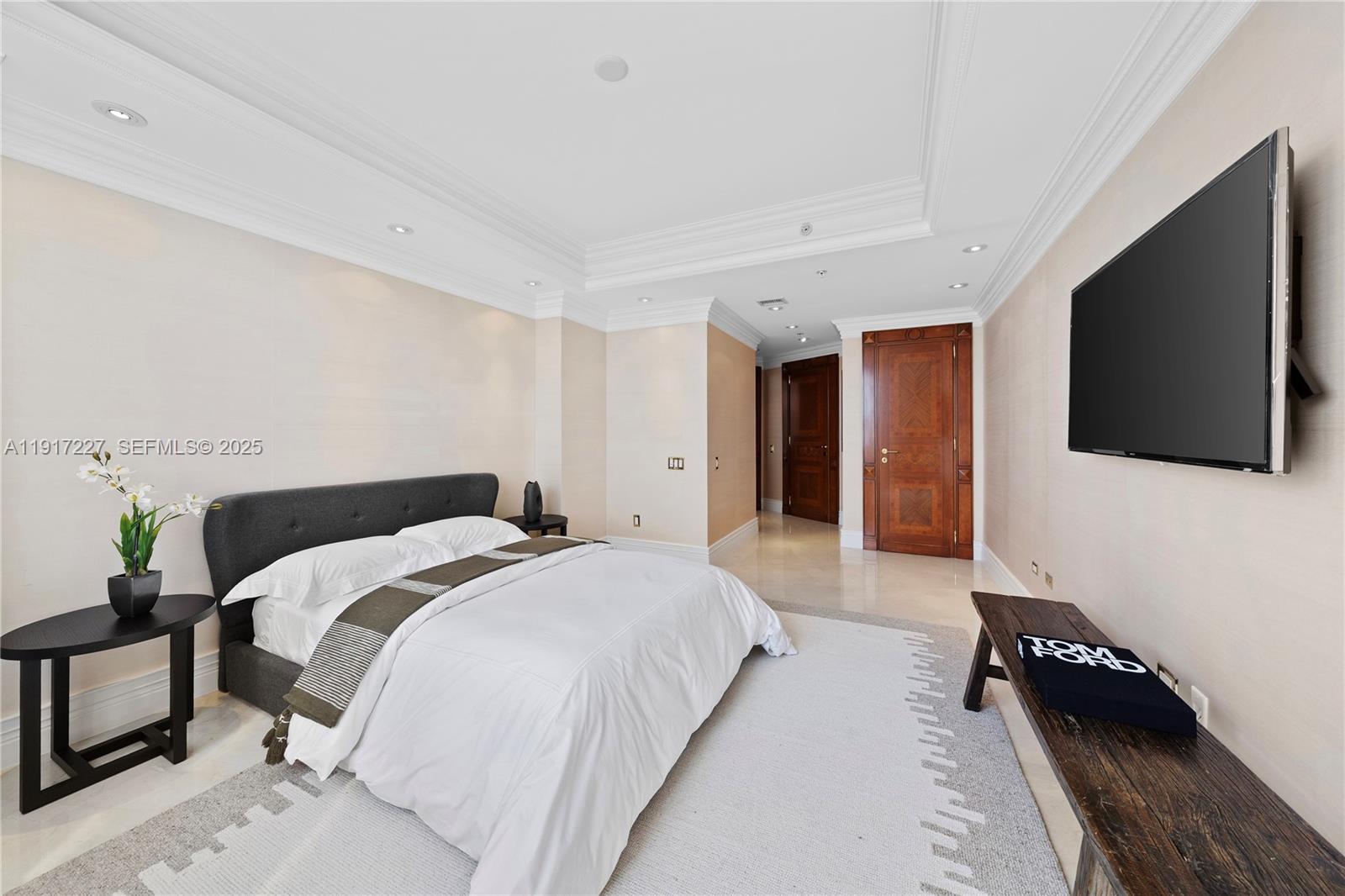 808 Brickell Key Drive, Unit 1802 Miami, FL 33131 - Photo 28 of 43 a spacious bedroom with a bed and a flat screen tv