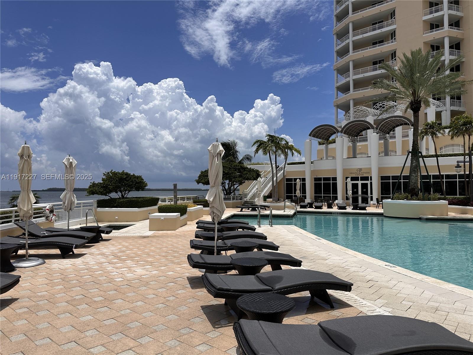 808 Brickell Key Drive, Unit 1802 Miami, FL 33131 - Photo 38 of 43 a view of a lake with couches and lounge chairs