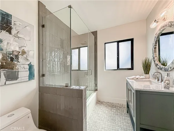 a bathroom with a double vanity sink toilet and shower