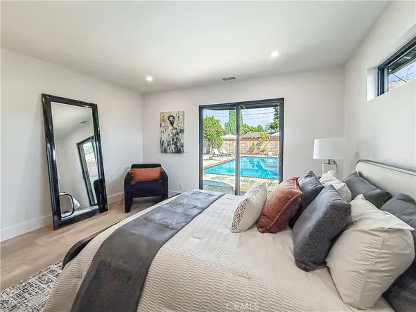 a bedroom with a bed and a large mirror