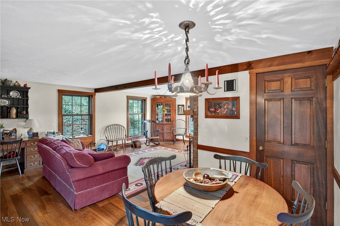 25700 Winona Road Homeworth, OH 44634 - Photo 11 of 49 Dining room featuring wood finished floors, beam ceiling, and a chandelier