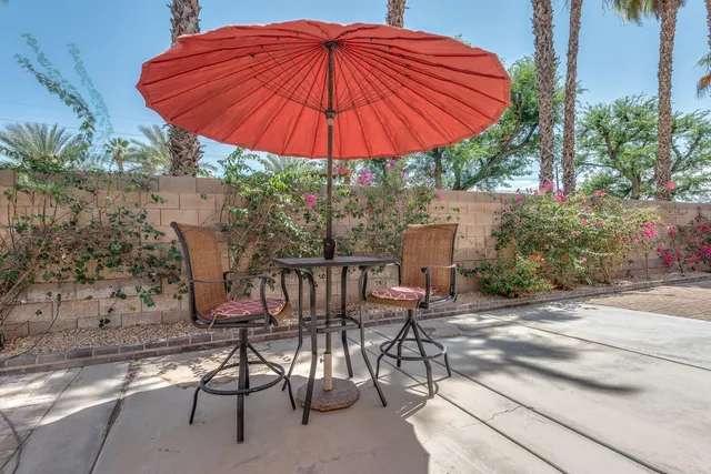 a patio with a patio table and chairs under an umbrella