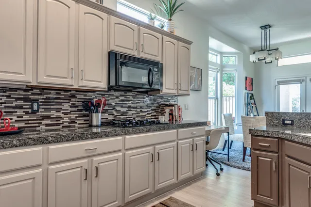 a kitchen with stainless steel appliances granite countertop a sink a stove and cabinets