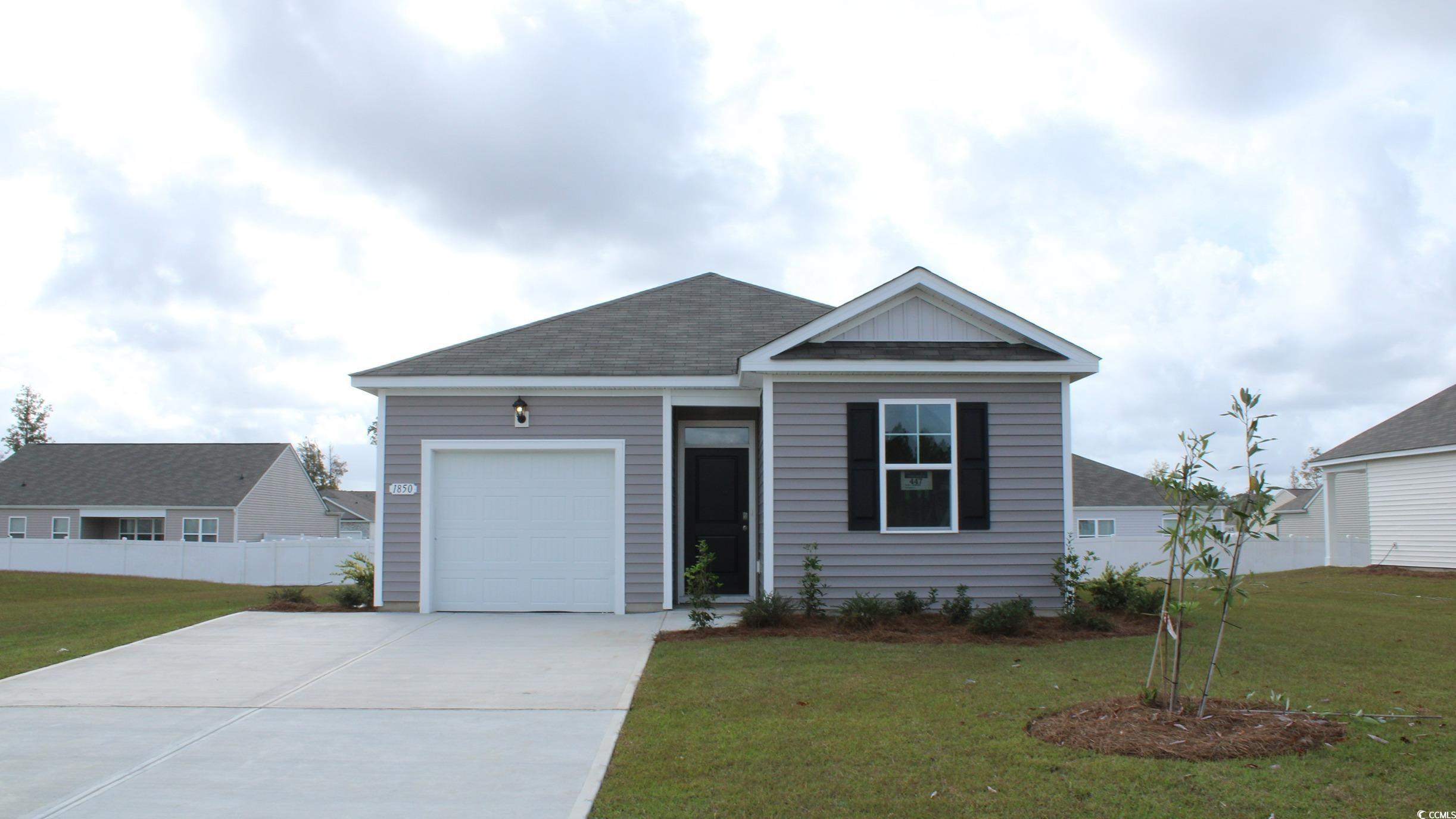 Single story home featuring roof with shingles, driveway, and an attached garage