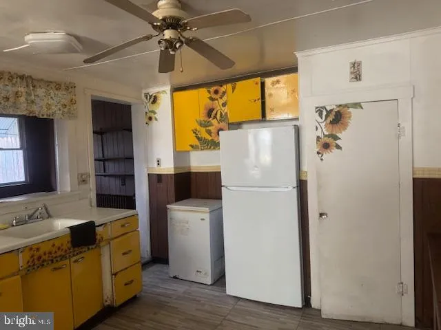 a kitchen with a refrigerator a sink and dishwasher with wooden floor
