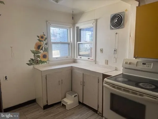 a kitchen with a sink cabinets and wooden floor