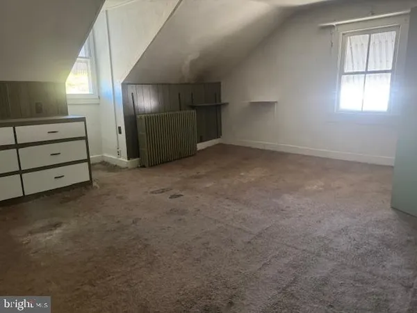an empty room with windows and cabinet