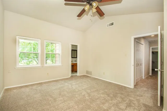 a view of a room with a empty space and a ceiling fan