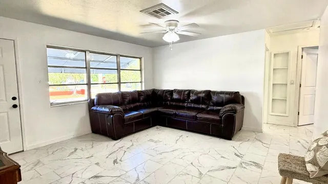 a living room with a large window and couches