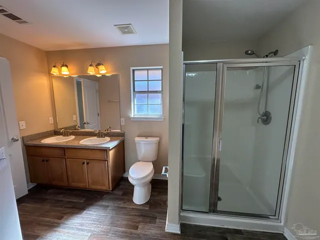 a bathroom with a granite countertop sink toilet a mirror and shower
